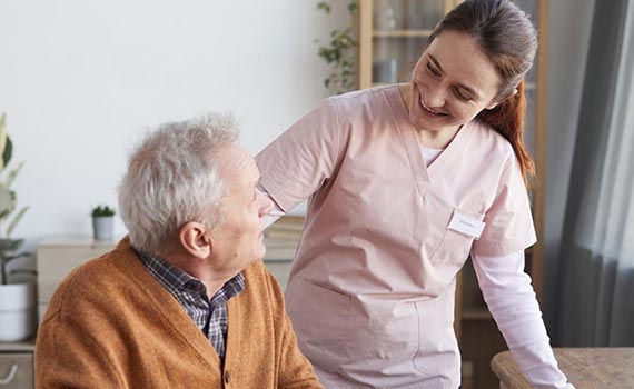 A nurse smiling looking at the old man