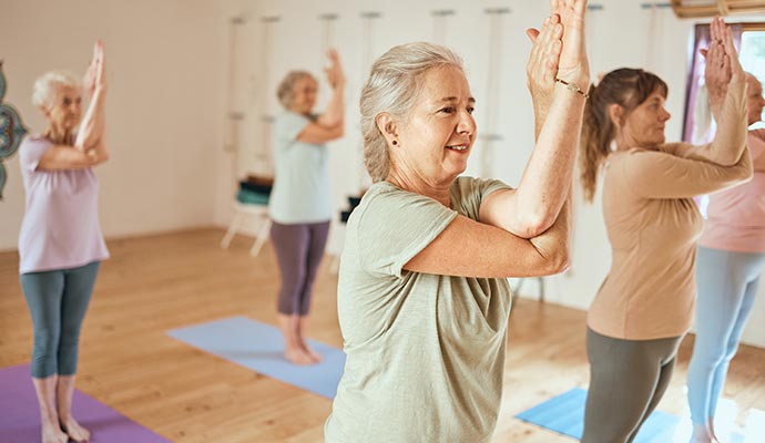 senior residents enjoying yoga in side a room