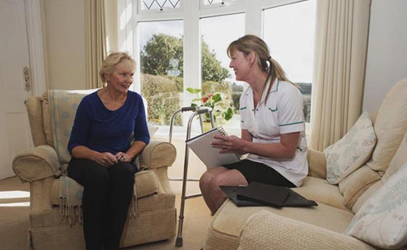 Nurse Talking with old woman taking necessary notes